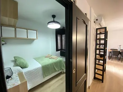 a small bedroom with a bed and a ladder at Apartmento Carmen Viejo, Centro in Sanlúcar de Barrameda