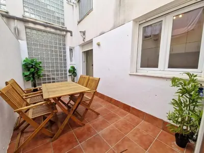 a patio with a wooden table and chairs on a balcony at CDZ - San Telmo in Cádiz