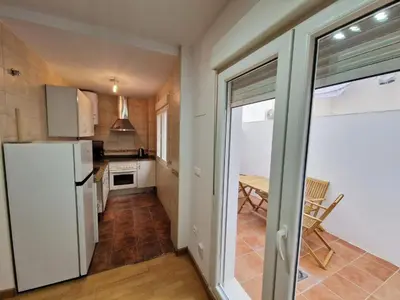 a kitchen with a white refrigerator and a table at CDZ - San Telmo in Cádiz