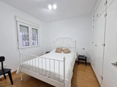 a white bedroom with a white bed and a window at CDZ - San Telmo in Cádiz