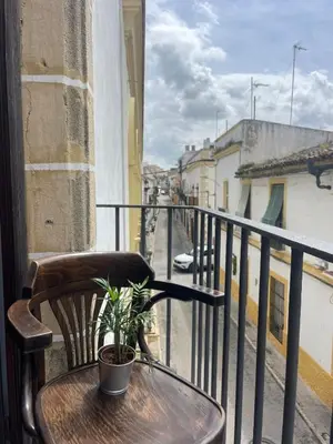 a table with a plant sitting on a balcony at El Buen Porvenir Casa Palacio en Jerez in Jerez de la Frontera