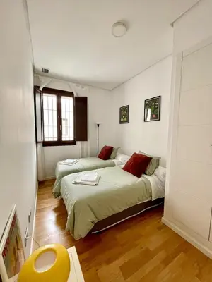 a bedroom with two beds and a window at El Buen Porvenir Casa Palacio en Jerez in Jerez de la Frontera