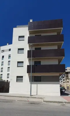a white building with black balconies on the side of it at Apartamento Azalea in El Puerto de Santa María