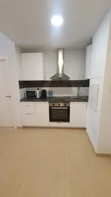a kitchen with white cabinets and a stove top oven at Apartamento Azalea in El Puerto de Santa María