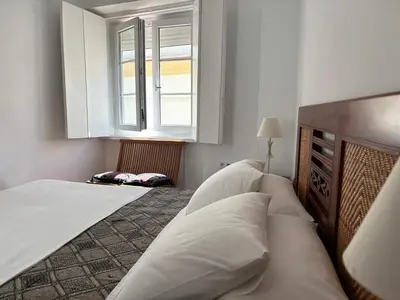 a bedroom with two beds and a window at Candelaria cornerflat in Cádiz