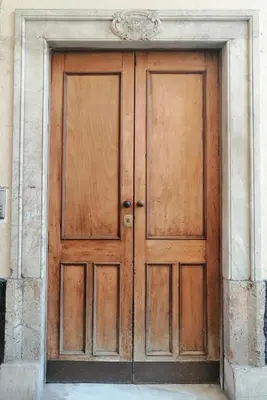 a wooden door in a building with a stone wall at Candelaria cornerflat in Cádiz