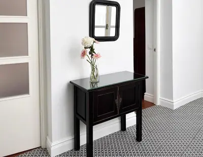 a vase of flowers on a table with a mirror at Candelaria cornerflat in Cádiz