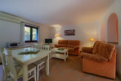 a living room with a couch and a table and chairs at Hacienda Roche Viejo in Conil de la Frontera