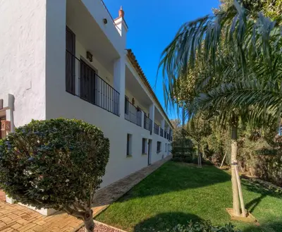 a building with a palm tree in front of it at Hacienda Roche Viejo in Conil de la Frontera
