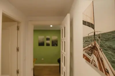 a hallway with a door with a painting on the wall at Apartamento The River in El Puerto de Santa María