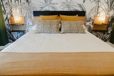 a bedroom with a large white bed with two lamps at Apartamento The River in El Puerto de Santa María