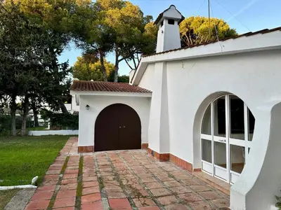 a small white building with a brown door at Pinos Verdes in Chiclana de la Frontera