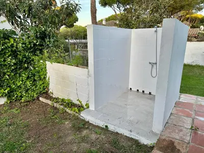 a white fence with a shower in a yard at Pinos Verdes in Chiclana de la Frontera
