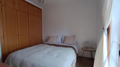 a bedroom with a bed and a wooden cabinet at Apartamento Maracaibo in Novo Sancti Petri