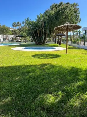 a grassy area with a umbrella in a park at Apartamento Maracaibo in Novo Sancti Petri