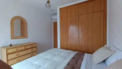 a bedroom with a bed and a wooden dresser at Apartamento Maracaibo in Novo Sancti Petri