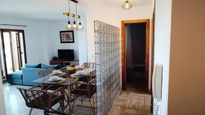 a living room with a table and a blue couch at Apartamento Maracaibo in Novo Sancti Petri
