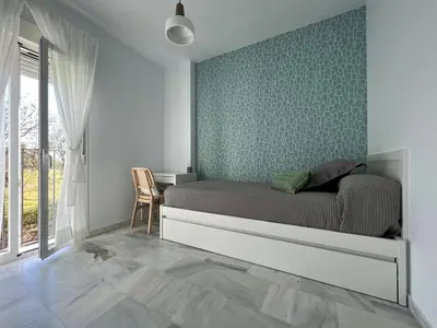 a bedroom with a bed with a green wall at Charming house Costa Ballena in Rota