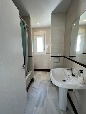 a white bathroom with a sink and a mirror at Charming house Costa Ballena in Rota