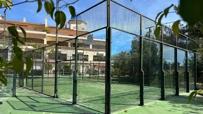 a tennis court with a net in front of a building at Charming house Costa Ballena in Rota