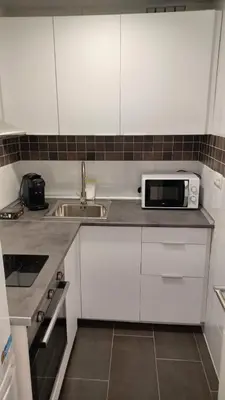 a white kitchen with a sink and a microwave at Apartamento Nuevo Céntrico El Puerto de Santa María in El Puerto de Santa María