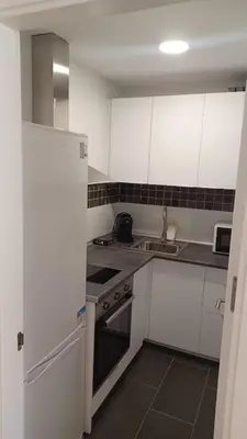 a kitchen with white cabinets and a stove and a sink at Apartamento Nuevo Céntrico El Puerto de Santa María in El Puerto de Santa María
