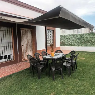 a table and chairs under a black umbrella on a lawn at El SITIO DE MI RECREO in El Puerto de Santa María