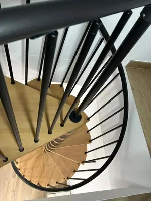 a spiral staircase with black railings and a wooden floor at Cozy Duplex 2 Bedrooms Apart - 200m to La Barrosa Beach in Novo Sancti Petri