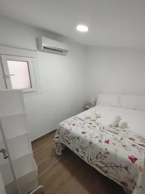 a white bedroom with a bed and a window at Cozy Duplex 2 Bedrooms Apart - 200m to La Barrosa Beach in Novo Sancti Petri