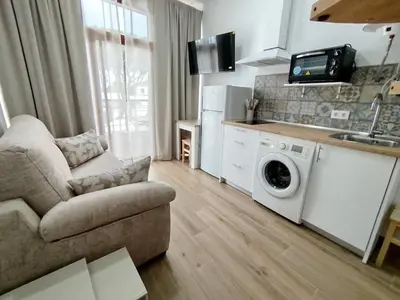 a living room with a couch and a washing machine at Cozy Duplex 2 Bedrooms Apart - 200m to La Barrosa Beach in Novo Sancti Petri