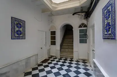 a hallway with a staircase and a checkered floor at Apartamento San Jose Grupo AC Gestion in Cádiz