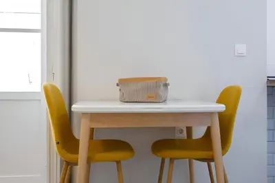 a table with two yellow chairs and a box on it at Apartamento San Jose Grupo AC Gestion in Cádiz