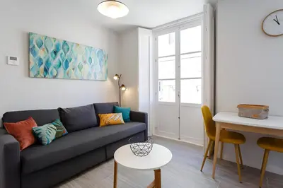 a living room with a couch and a table at Apartamento San Jose Grupo AC Gestion in Cádiz