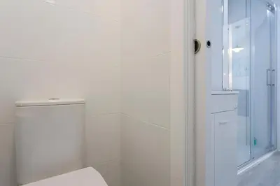 a white bathroom with a shower and a toilet at Apartamento San Jose Grupo AC Gestion in Cádiz