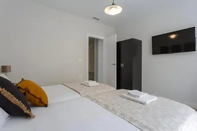 a white bed with two towels on top of it at Apartamento San Jose Grupo AC Gestion in Cádiz