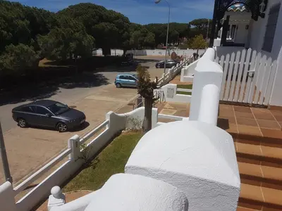 a white fence with a car parked in a parking lot at La Almadraba segunda Pista in Chiclana de la Frontera