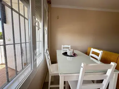 a white table and chairs in a room with a window at La Almadraba segunda Pista in Chiclana de la Frontera