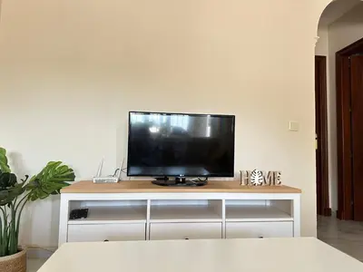 a flat screen tv sitting on top of a white entertainment center at La Almadraba segunda Pista in Chiclana de la Frontera