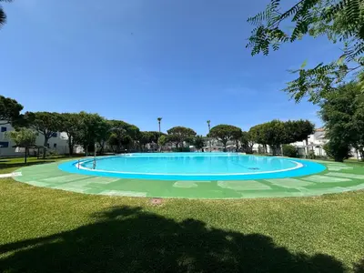 a large blue swimming pool in a park at La Almadraba segunda Pista in Chiclana de la Frontera