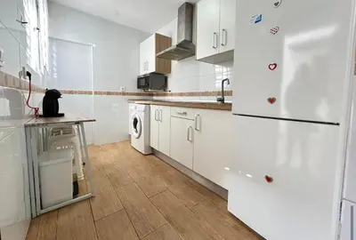 a kitchen with white cabinets and a black cat sitting on a counter at Sueños de Santiago in Jerez de la Frontera