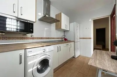 a kitchen with a washing machine and a microwave at Sueños de Santiago in Jerez de la Frontera