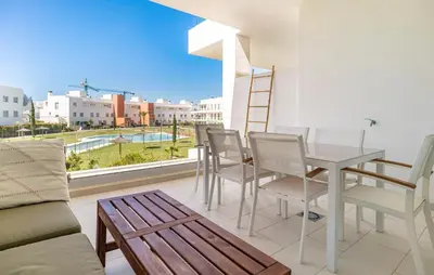 a living room with a table and chairs on a balcony at Beautiful Apartment In Chipiona in Chipiona