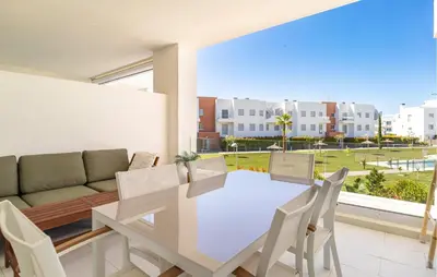 a dining room with a table and chairs and a couch at Beautiful Apartment In Chipiona in Chipiona