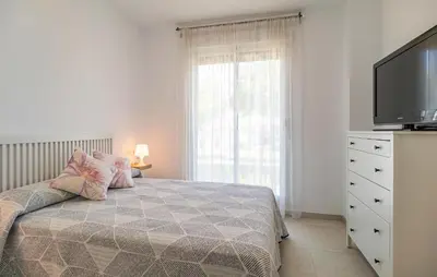 a bedroom with a bed and a flat screen tv at Beautiful Apartment In Chipiona in Chipiona