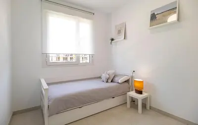 a white bedroom with a bed and a window at Beautiful Apartment In Chipiona in Chipiona