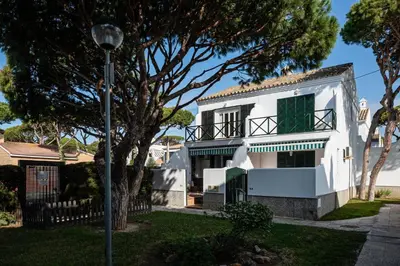 a white house with a green window and a street light at Arenas 65 in Chiclana de la Frontera