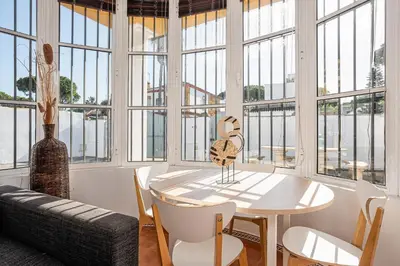 a dining room with a table and chairs and windows at MESANA in Chiclana de la Frontera