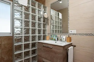 a bathroom with a sink and a large glass wall at MESANA in Chiclana de la Frontera