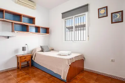 a small bedroom with a bed and a window at MESANA in Chiclana de la Frontera