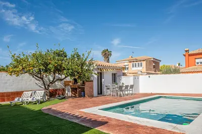 a backyard with a swimming pool and a house at MESANA in Chiclana de la Frontera